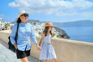 Mother and daughter walking along the Caldera, on the way to discovering that Santorini is good for families.